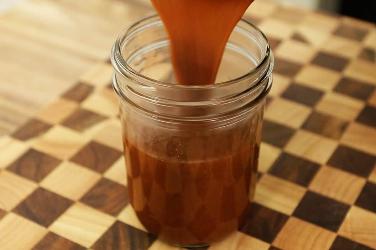 pouring enchilada sauce into a jar