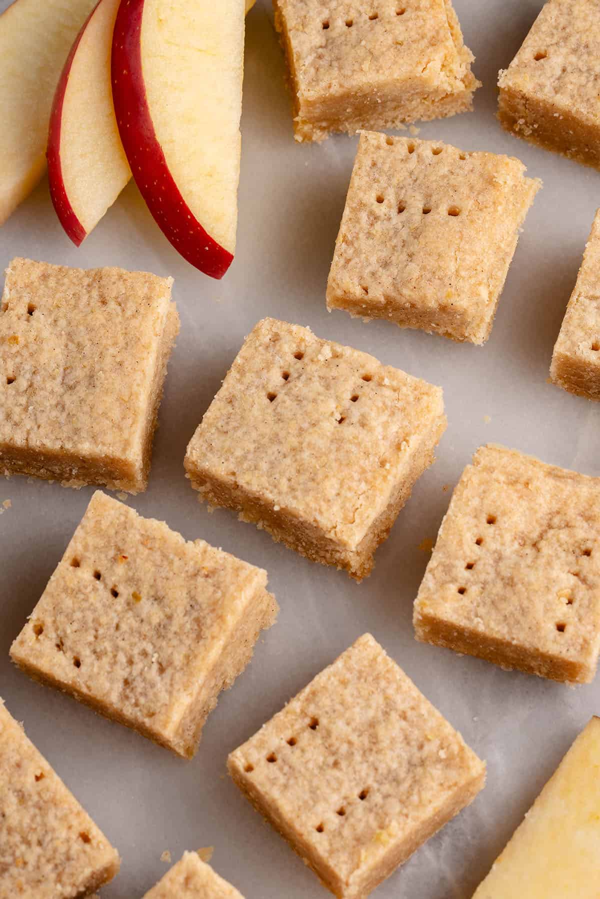 cinnamon apple shortbread bars on a white platter with sliced apples