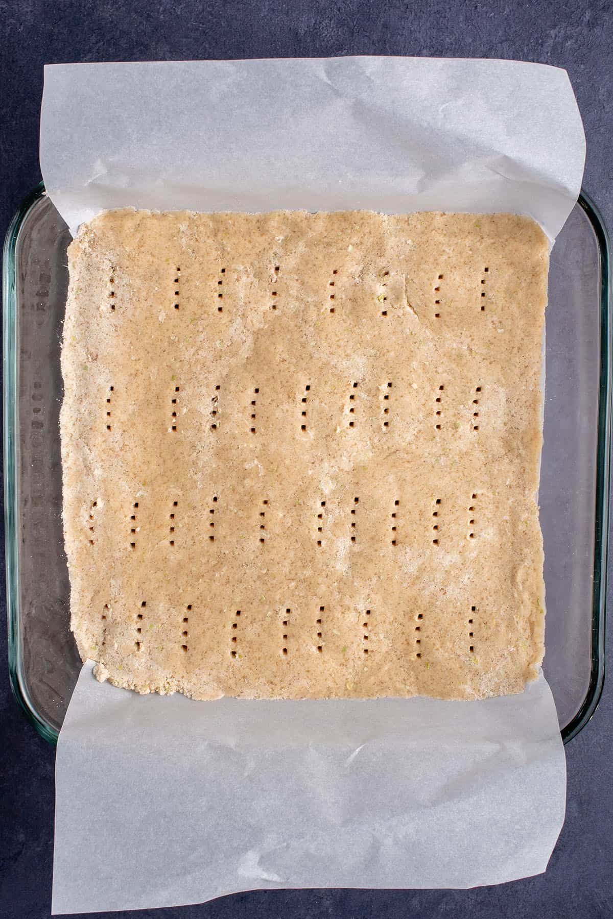 unbaked cinnamon apple shortbread in a tray over parchment paper