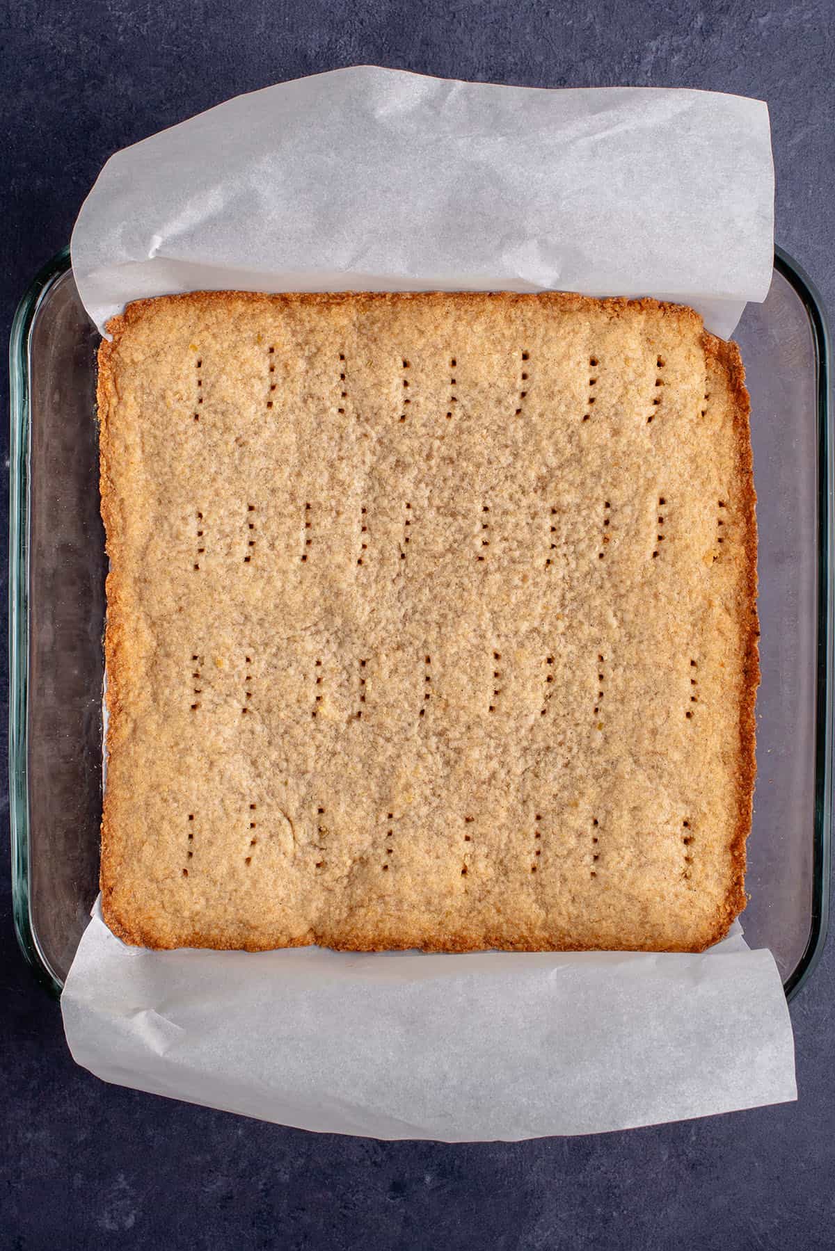 baked cinnamon apple shortbread in a tray over parchment paper