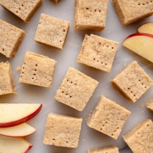 cinnamon apple shortbread bars on a white platter with sliced apples