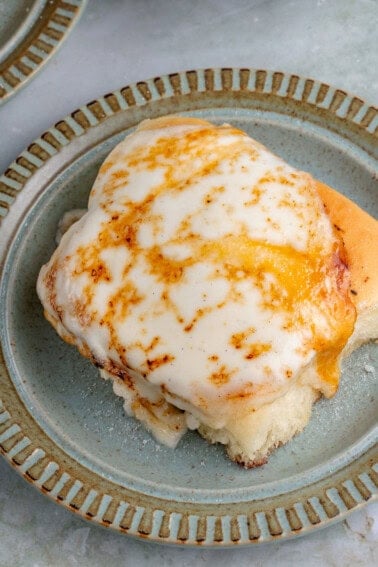 overhead of vegan Creme Brûlée cinnamon roll on blue plate