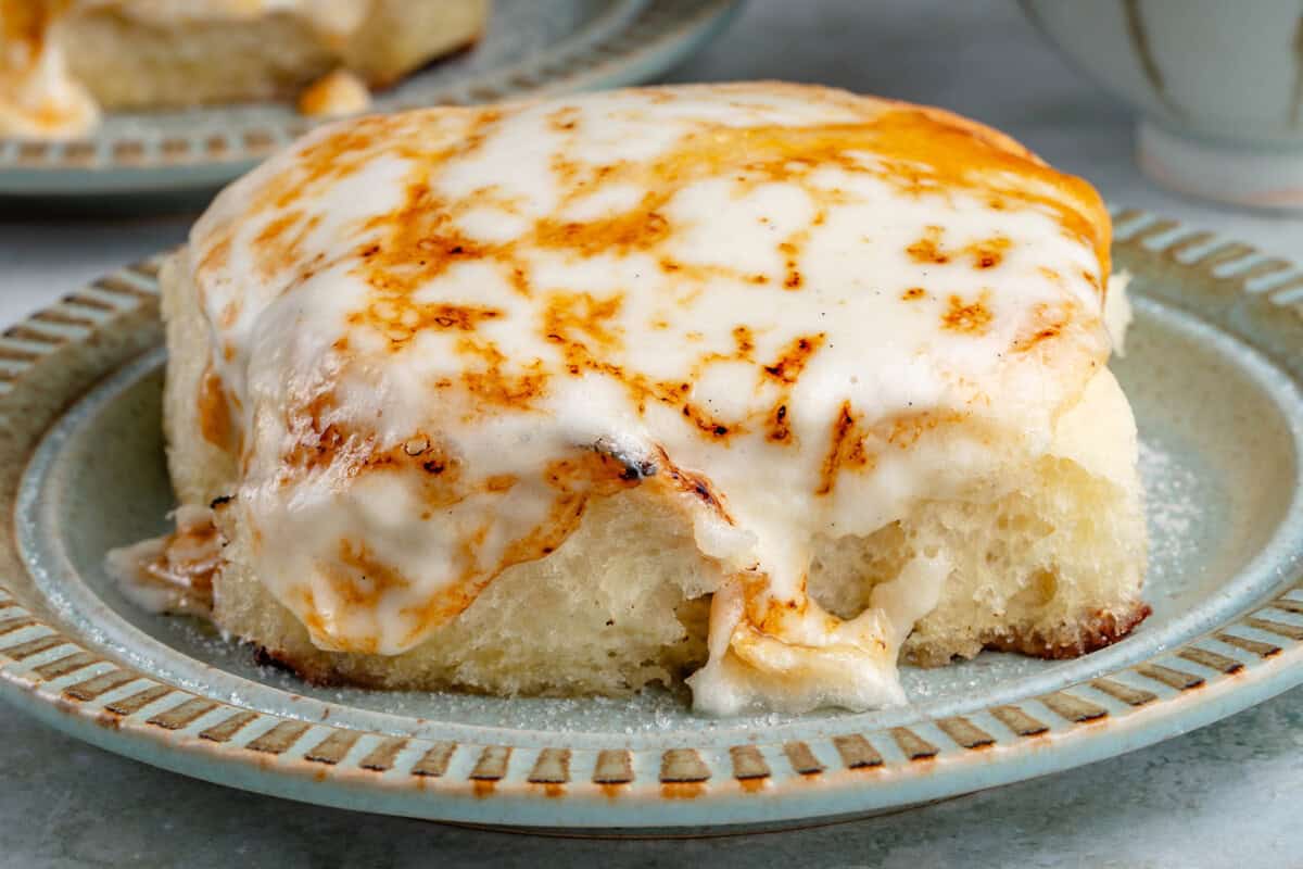 close up of a Creme Brûlée cinnamon roll on a blue plate