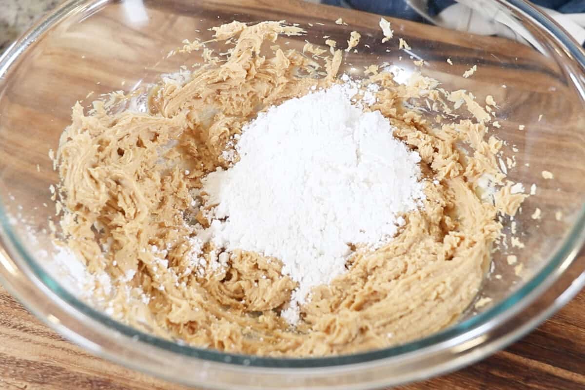 adding powdered sugar to whipped peanut butter and cream cheese