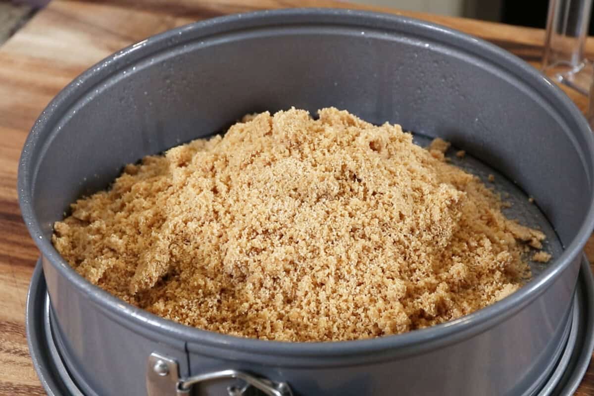 adding graham cracker crust to a springform pan