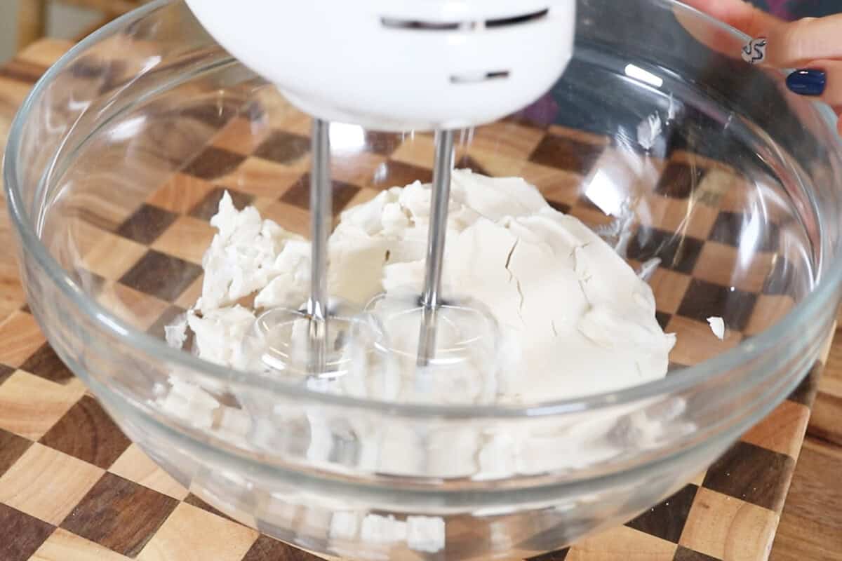 whipping cream cheese in a bowl with a handmixer