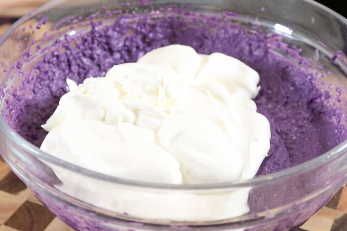 adding whipped heavy cream to a large bowl