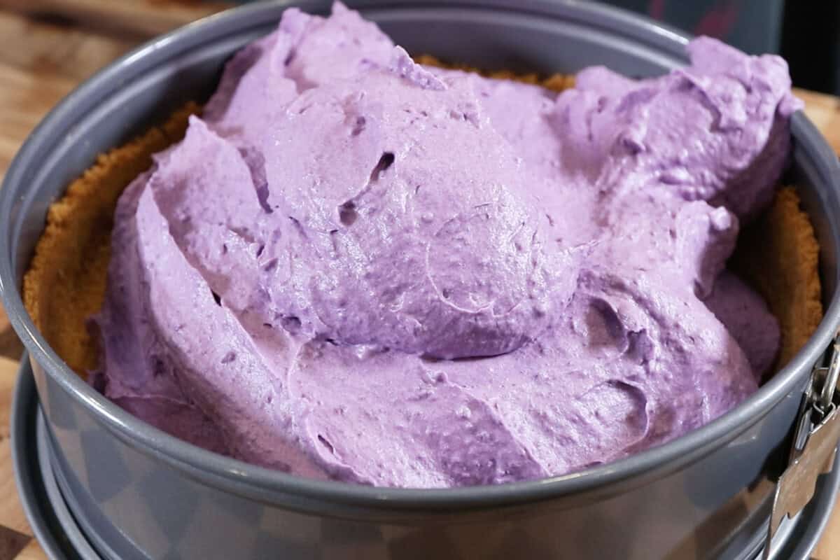 adding filling of ube pie in a springform pan