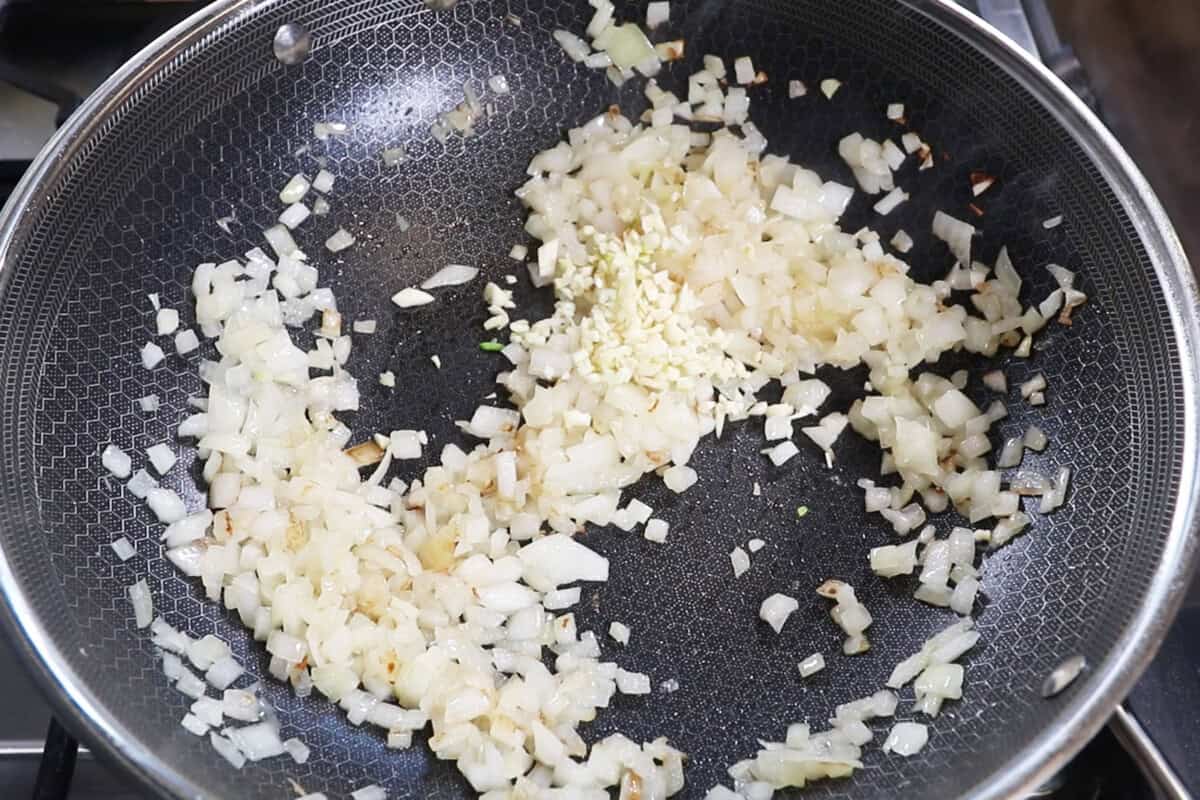 adding garlic to sautéd onions