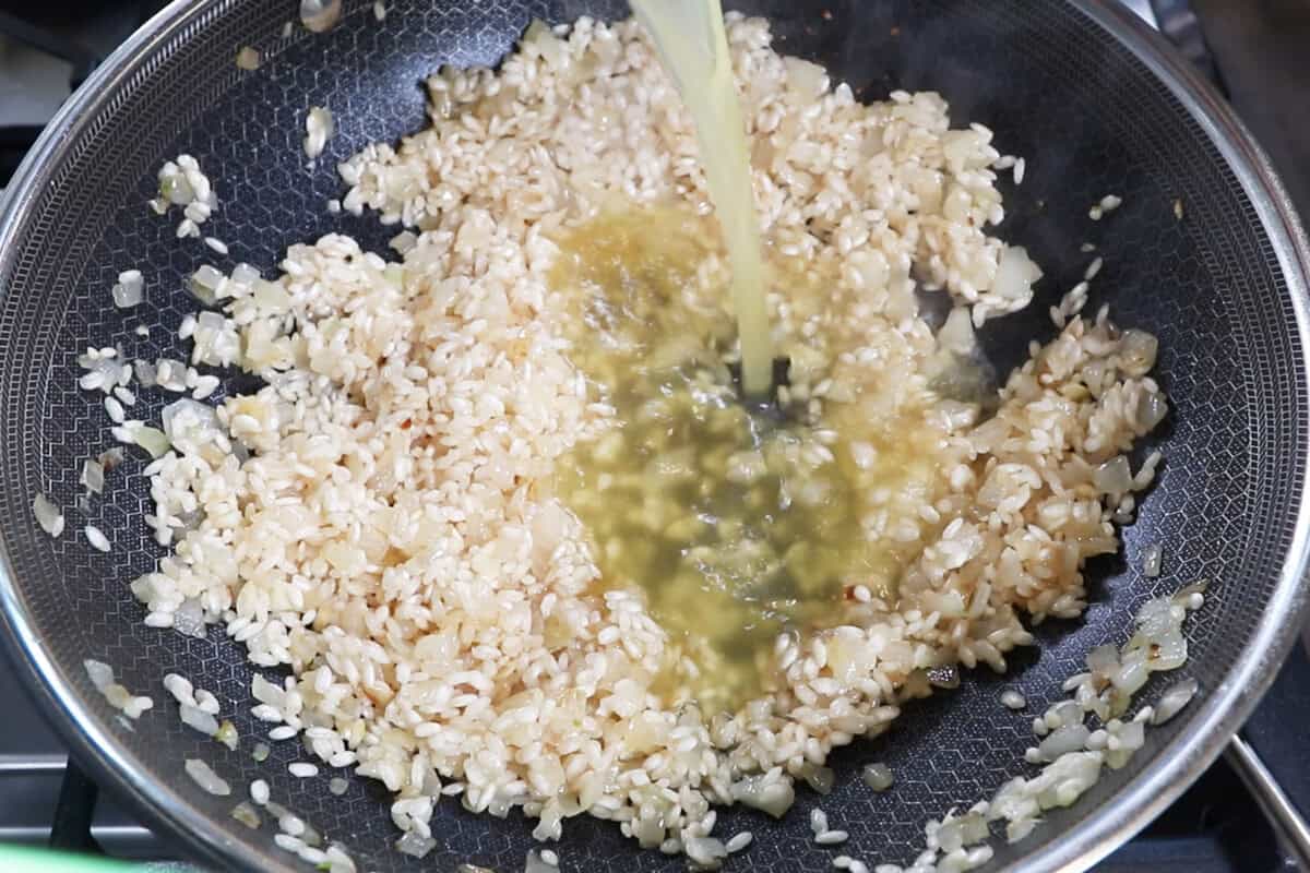 adding broth to rice