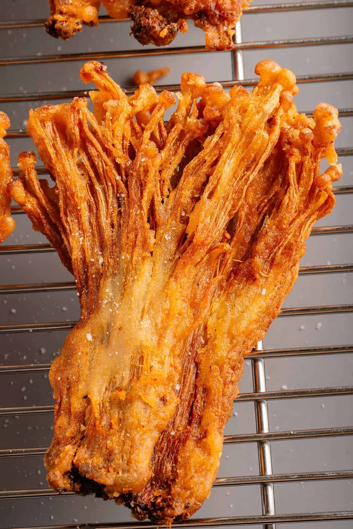 closeup of fried enoki mushrooms topped with salt