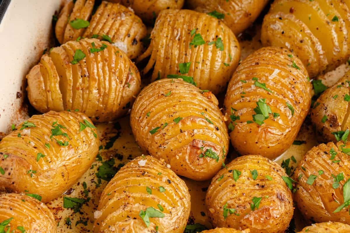 roasted hasselback potatoes topped with parsley