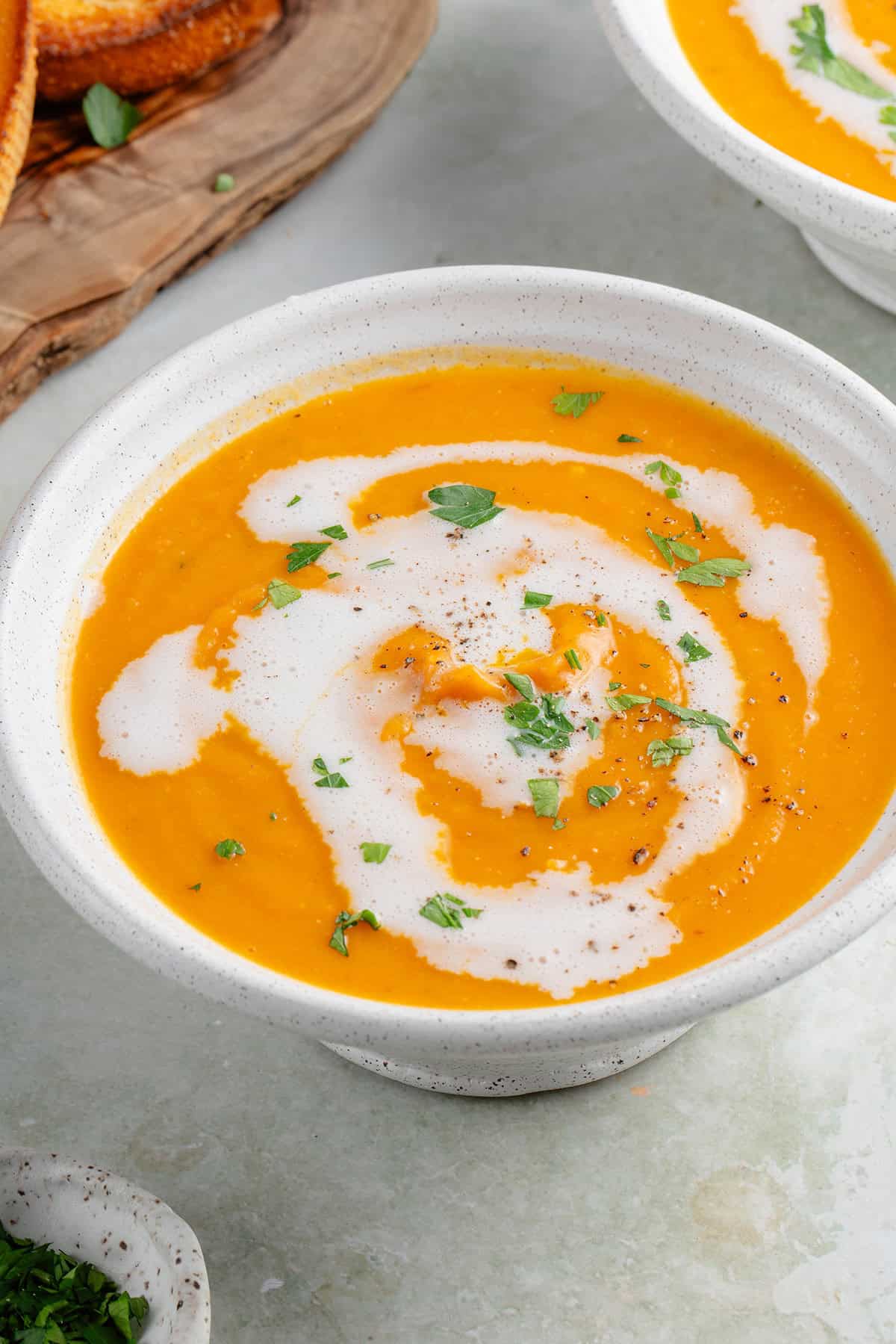 bowl of roasted sweet potato soup topped with coconut milk and parsley