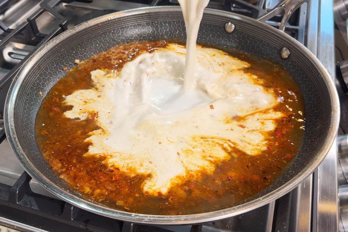 adding cashew cream to skillet