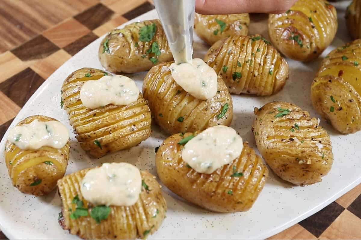 topping the hasselback potatoes with sour cream and onion dip