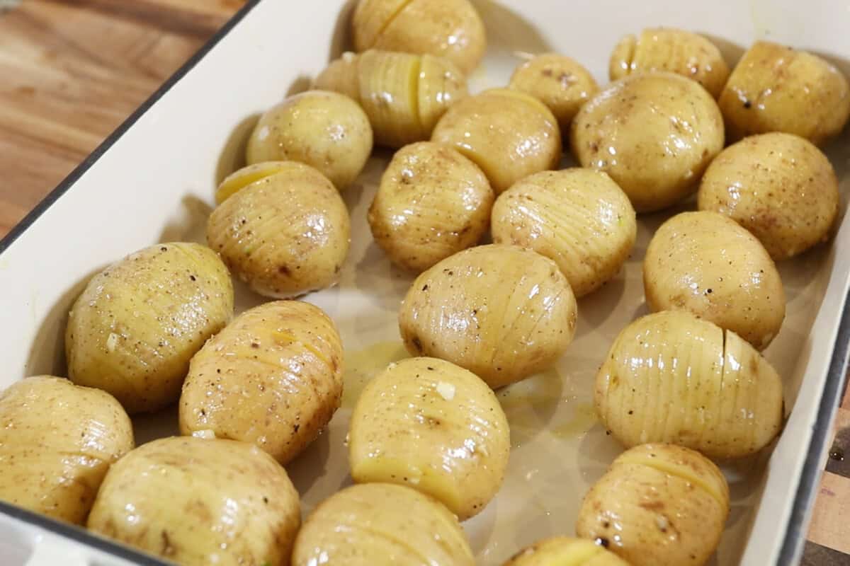 sliced and seasoned potatoes in a baking dish