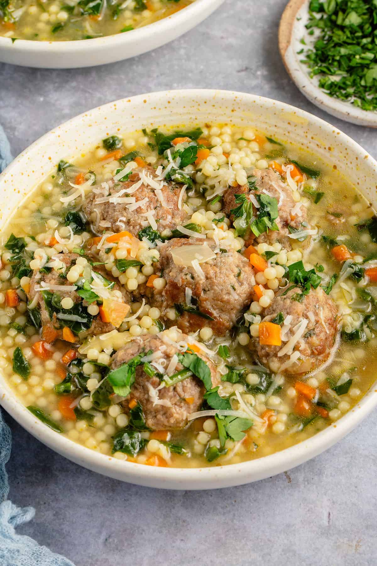 bowl of vegan italian wedding soup topped with parmesan