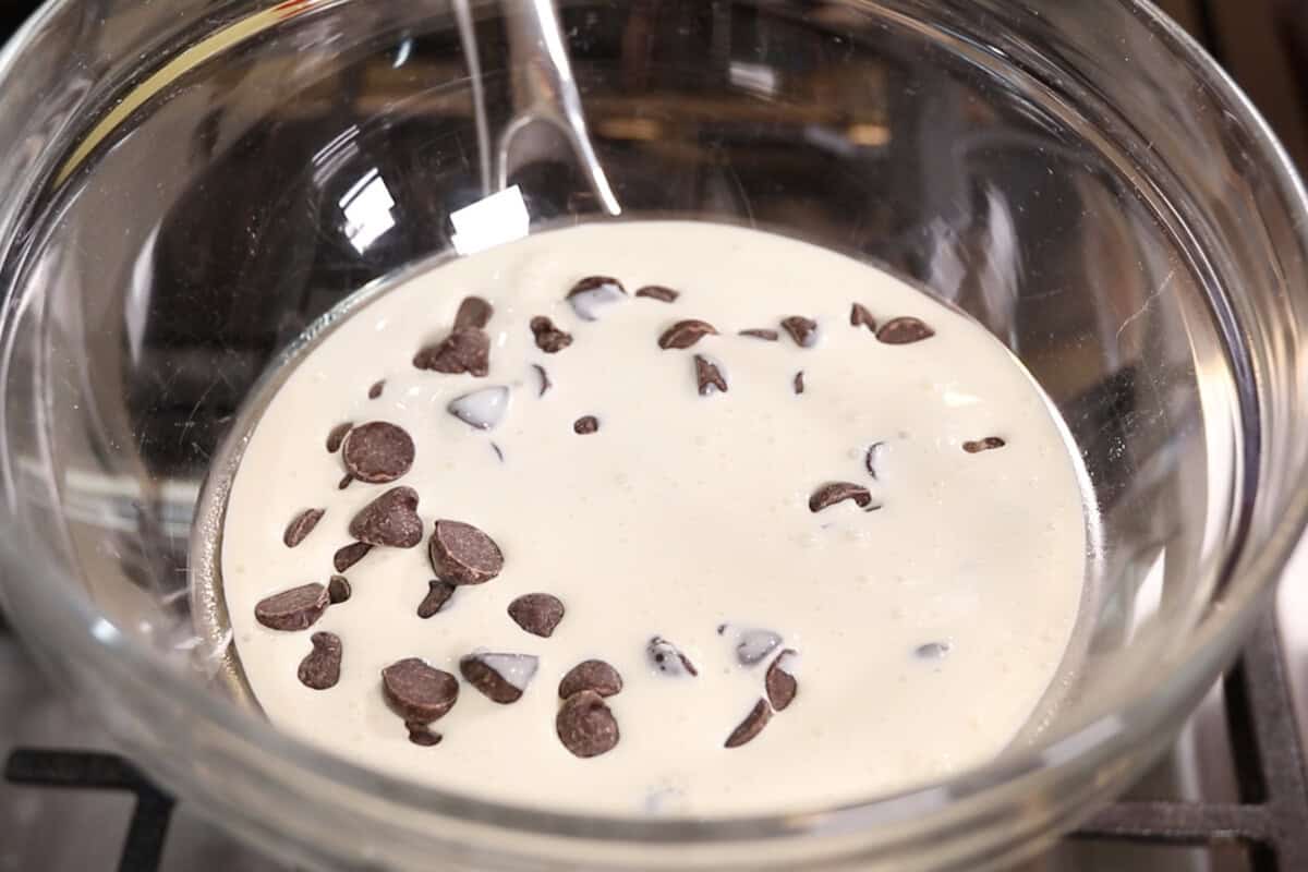 chocolate chips and heavy cream in a double boiler on the stove