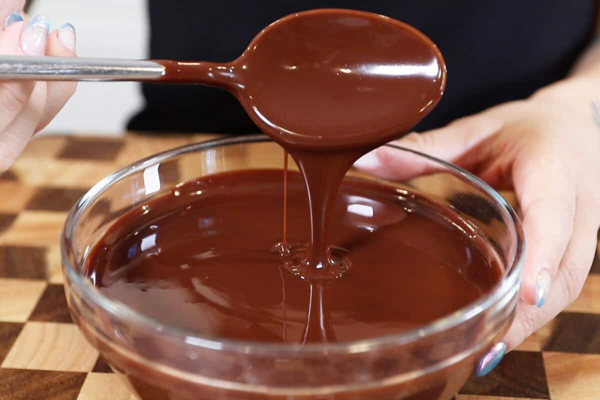 spoonful of chocolate ganache dripping back into the bowl