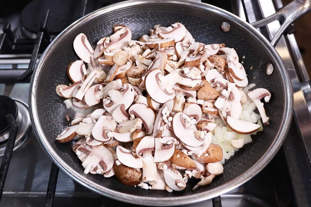 adding mushrooms to the pan