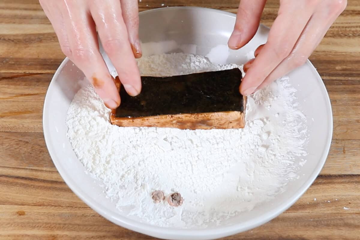 tossing the marinated tofu in a cornstarch dredge