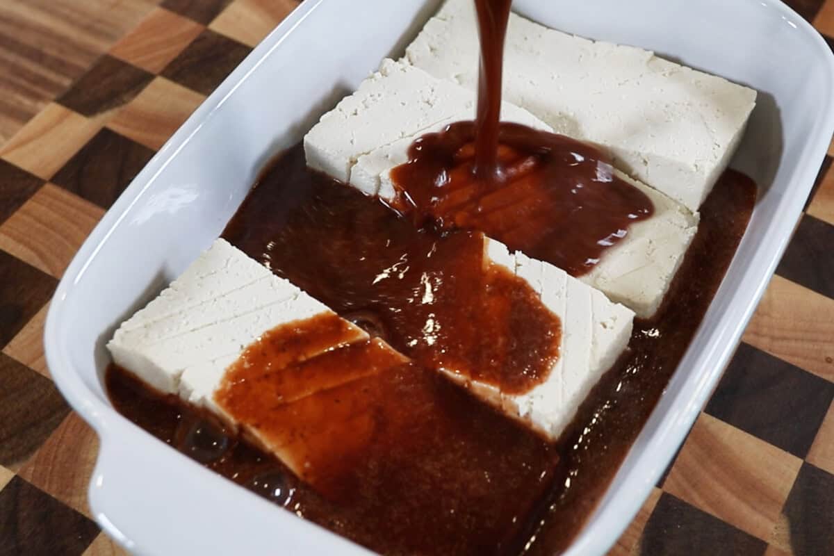 pouring marinade over tofu