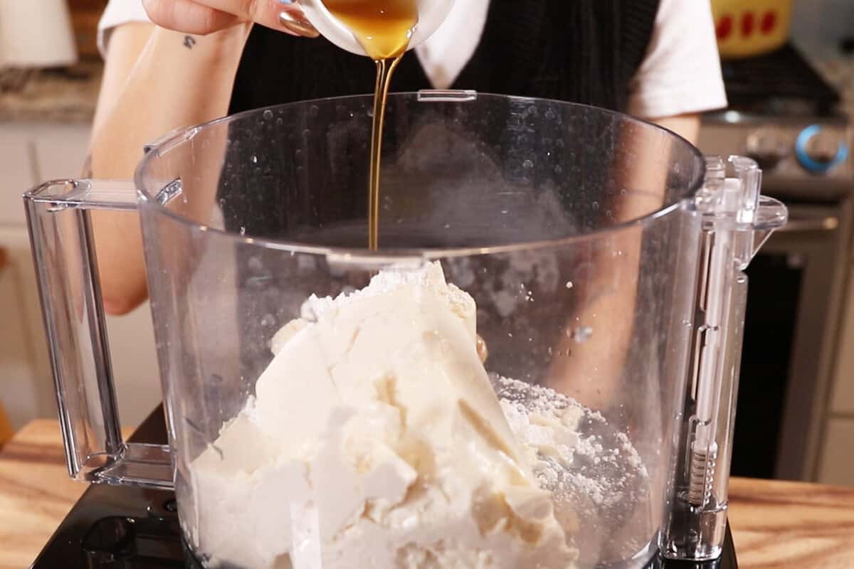 adding maple syrup into the food processor