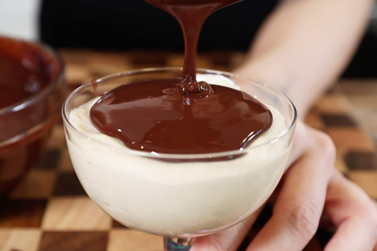 pouring chocolate ganache over peanut butter mousse