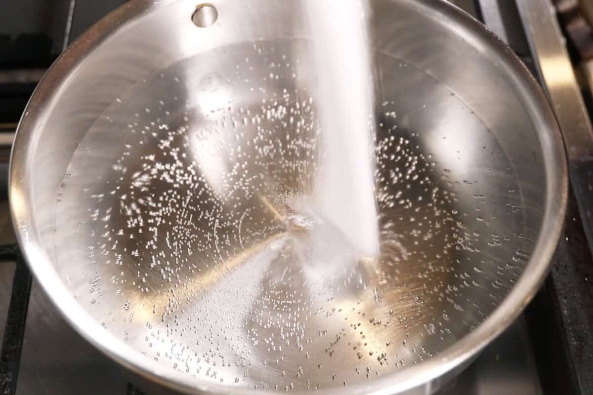 adding salt to a pot of water