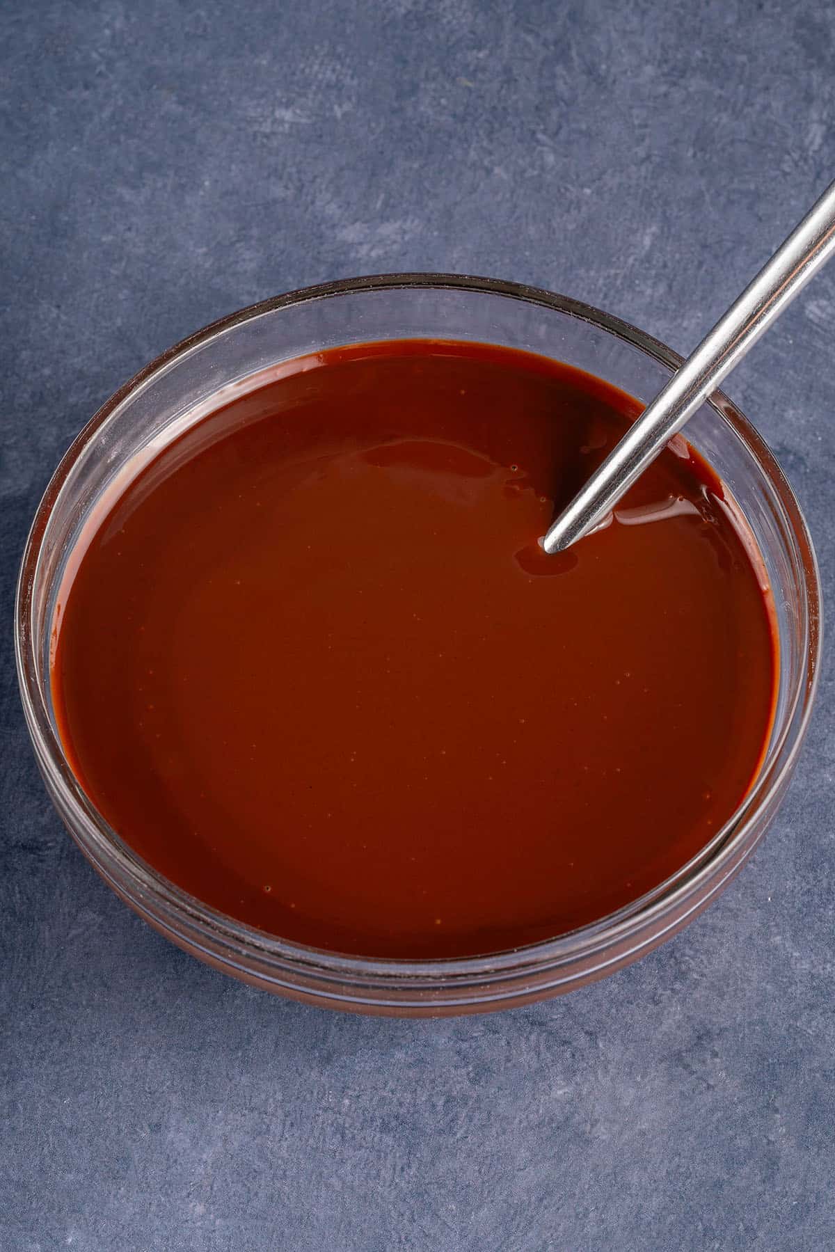 bowl of chocolate ganache with a spoon inside