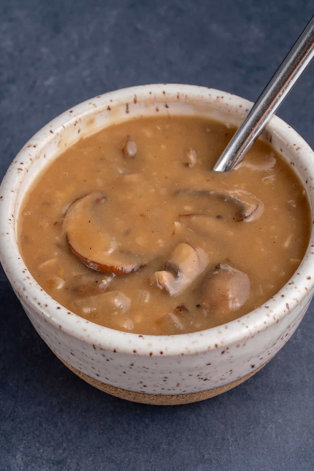 mushroom gravy in a small bowl with a spoon