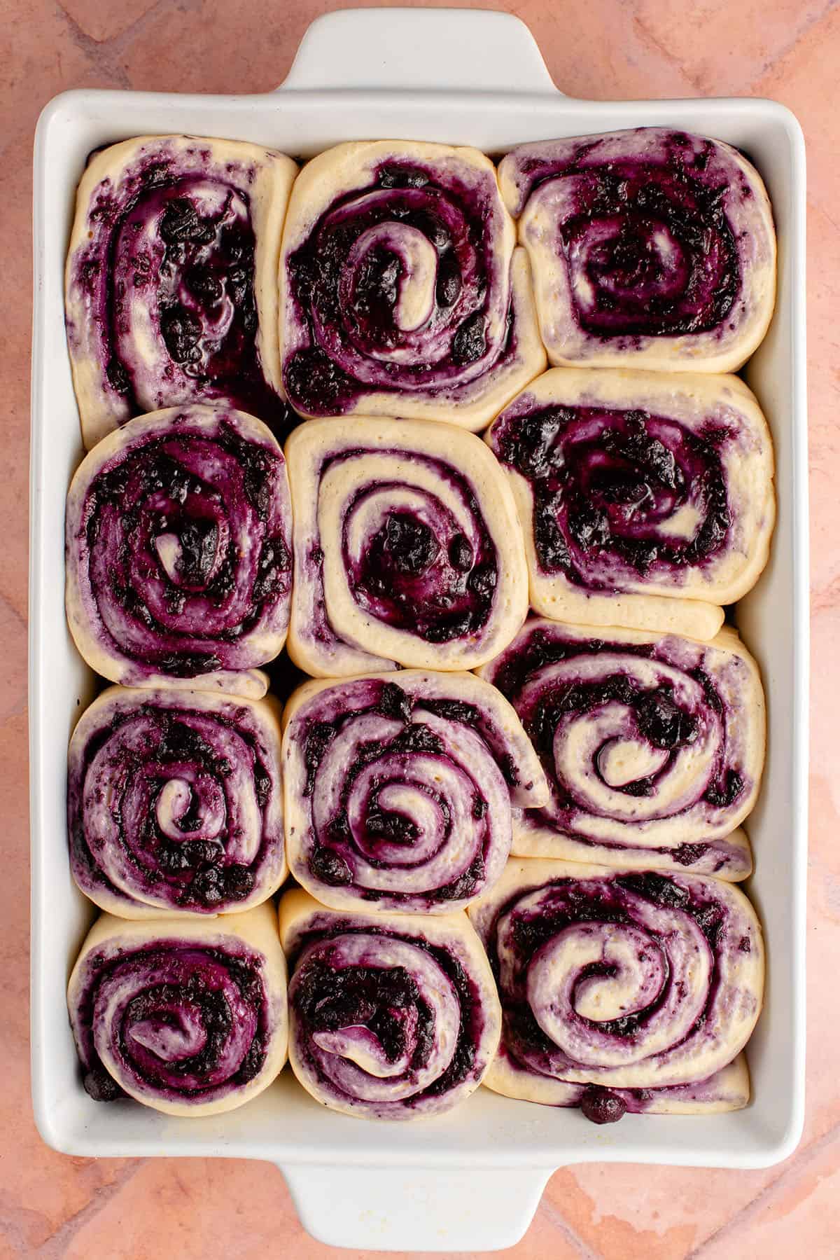 overhead photo of a tray of lemon blueberry rolls before baking