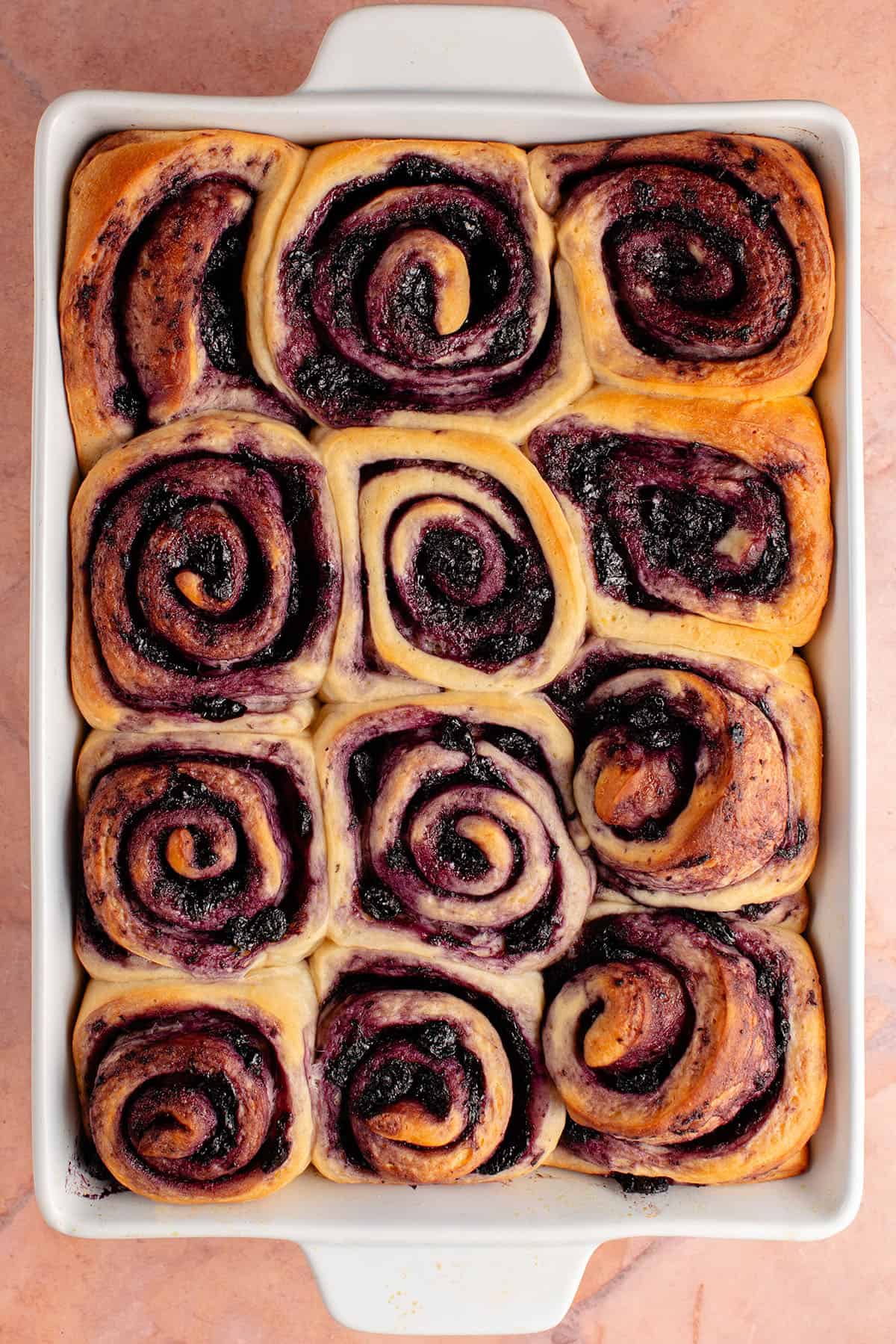 overhead photo of a tray of lemon blueberry rolls after baking
