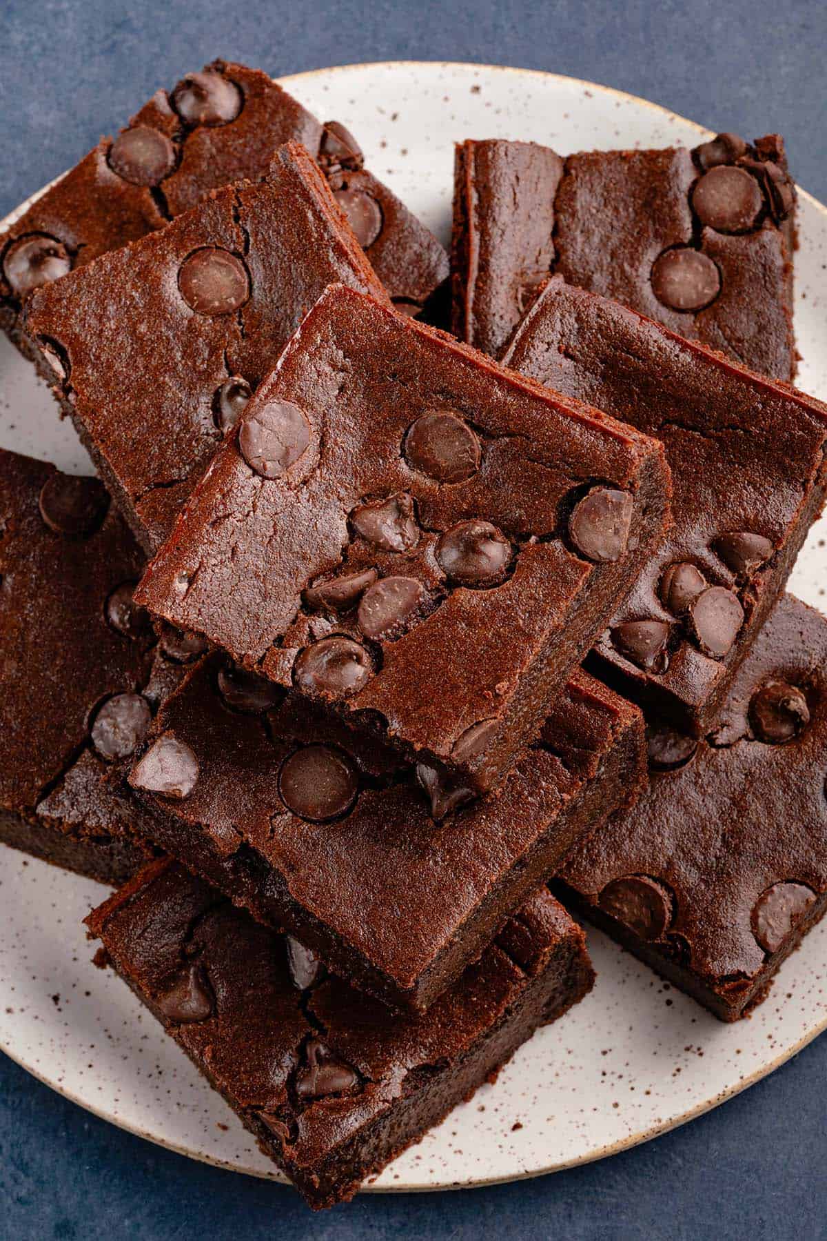 overhead of vegan mochi brownies stacked on white plate