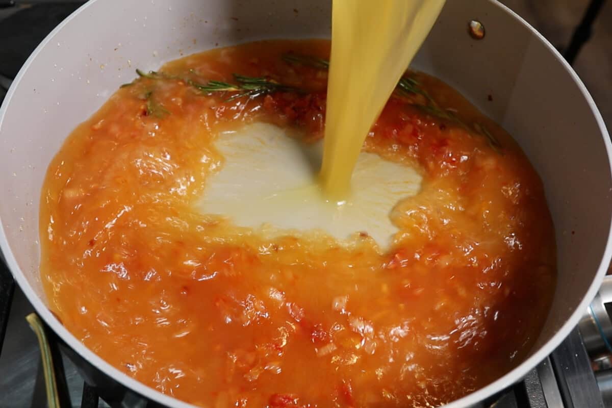 adding broth to the dutch oven