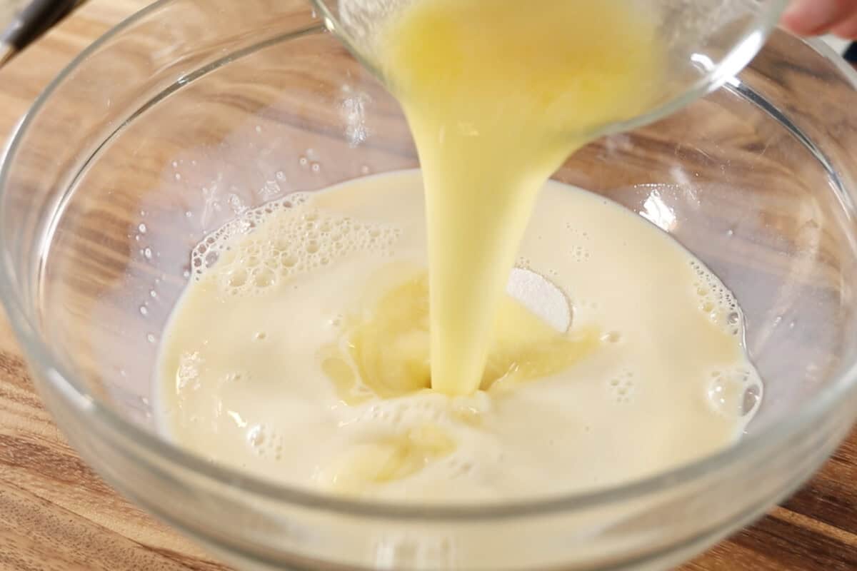 mixing wet ingredients for for Vegan Lemon Blueberry Sweet Rolls in large glass bowl