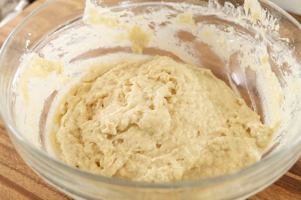 making dough for Vegan Lemon Blueberry Sweet Rolls in large glass bowl
