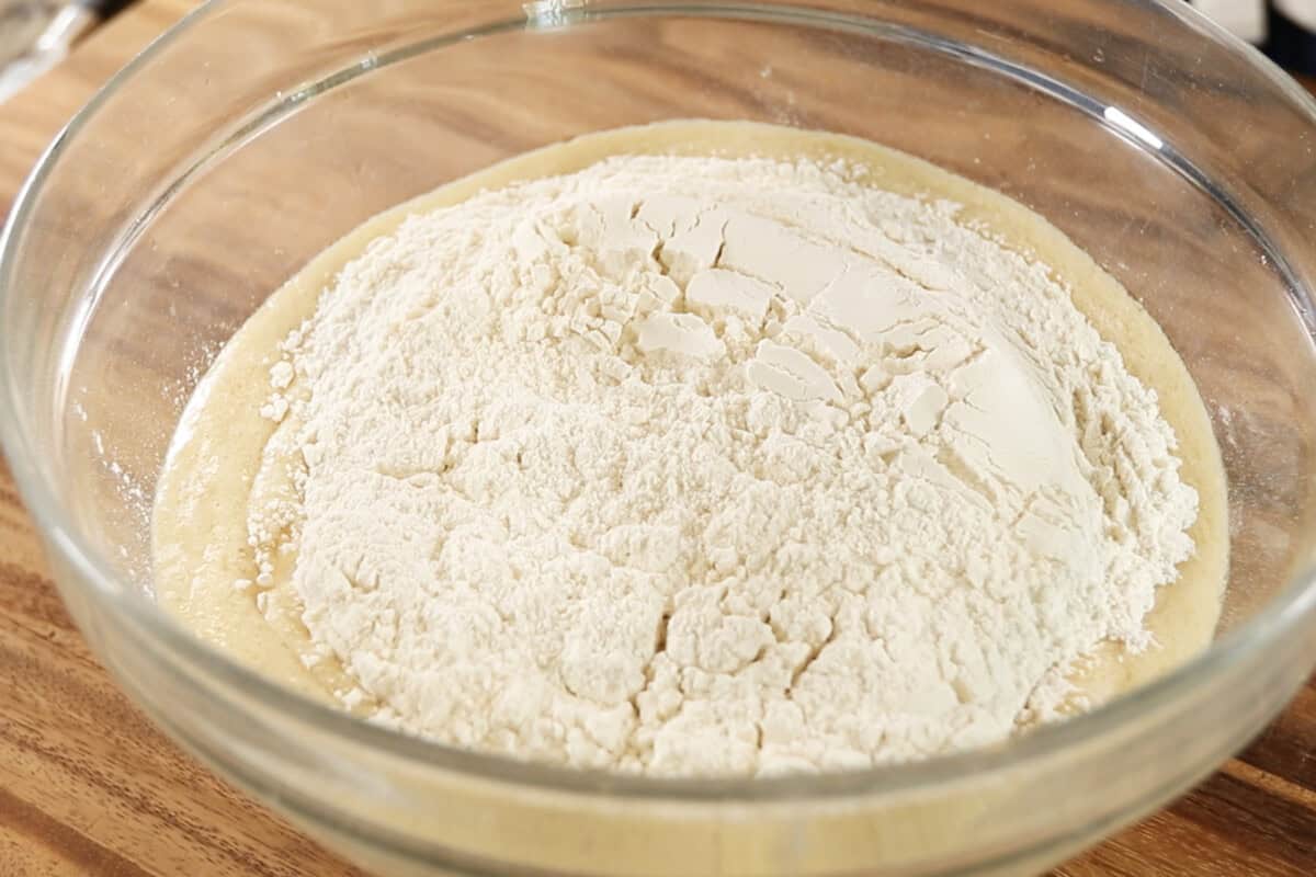 making dough for Vegan Lemon Blueberry Sweet Rolls in large glass bowl