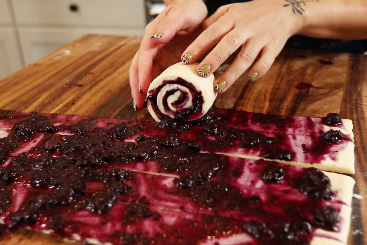 rolling Vegan Lemon Blueberry Sweet Rolls before baking