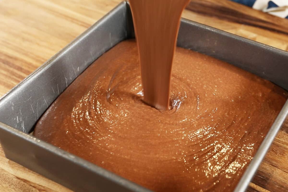 pouring batter into square baking pan