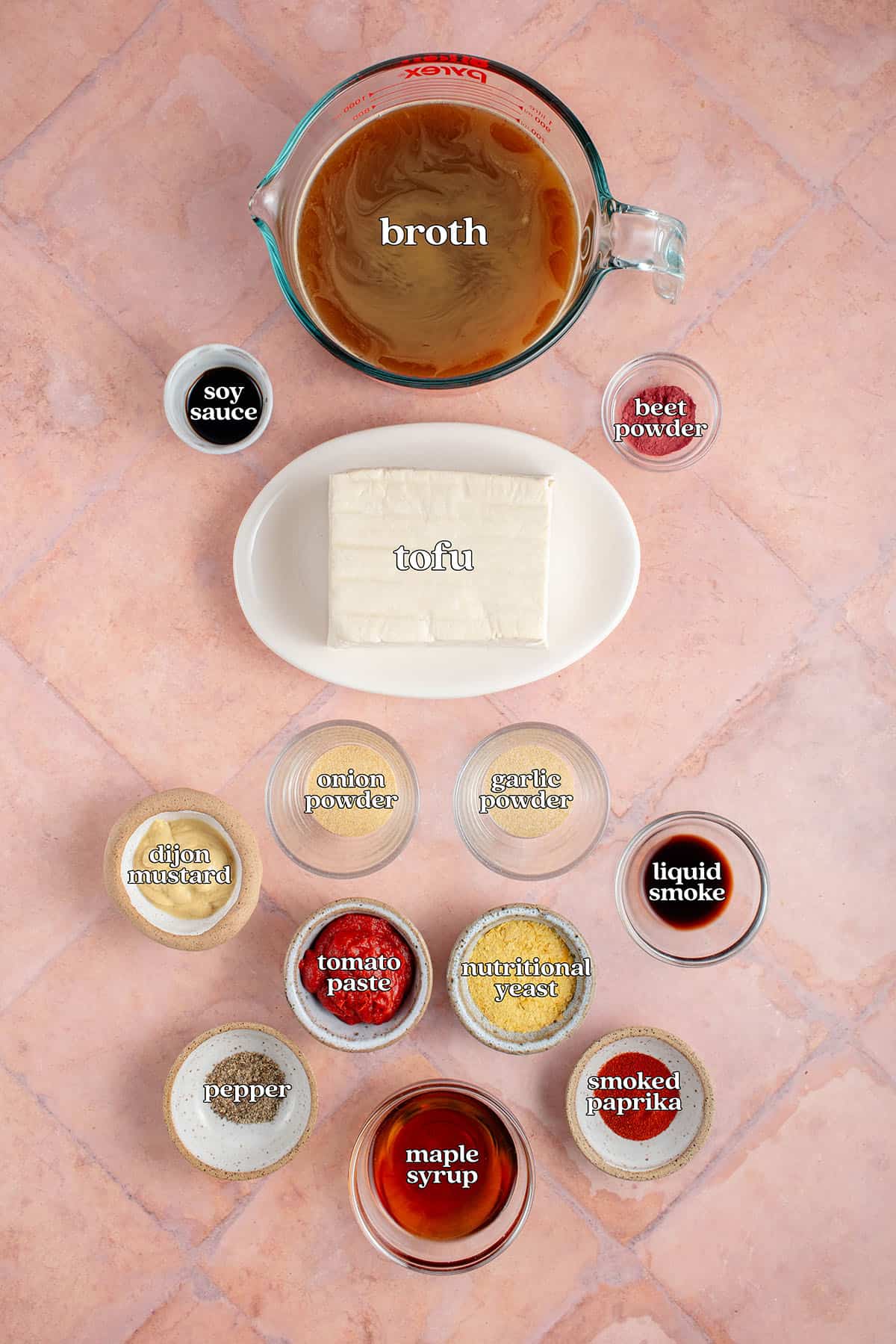 labeled ingredients for Ham-Style Tofu Deli Meat Slices in large pot: broth, soy sauce, beet powder, tofu, onion powder, garlic powder, dijon mustard, tomato pate, nutritional yeast, liquid smoke, black pepper, maple syrup and smoke paprika