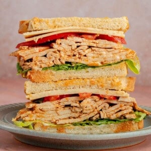 stacked sandwich with Ham-Style Tofu Deli Meat Slices, lettuce, tomato and vegan cheese