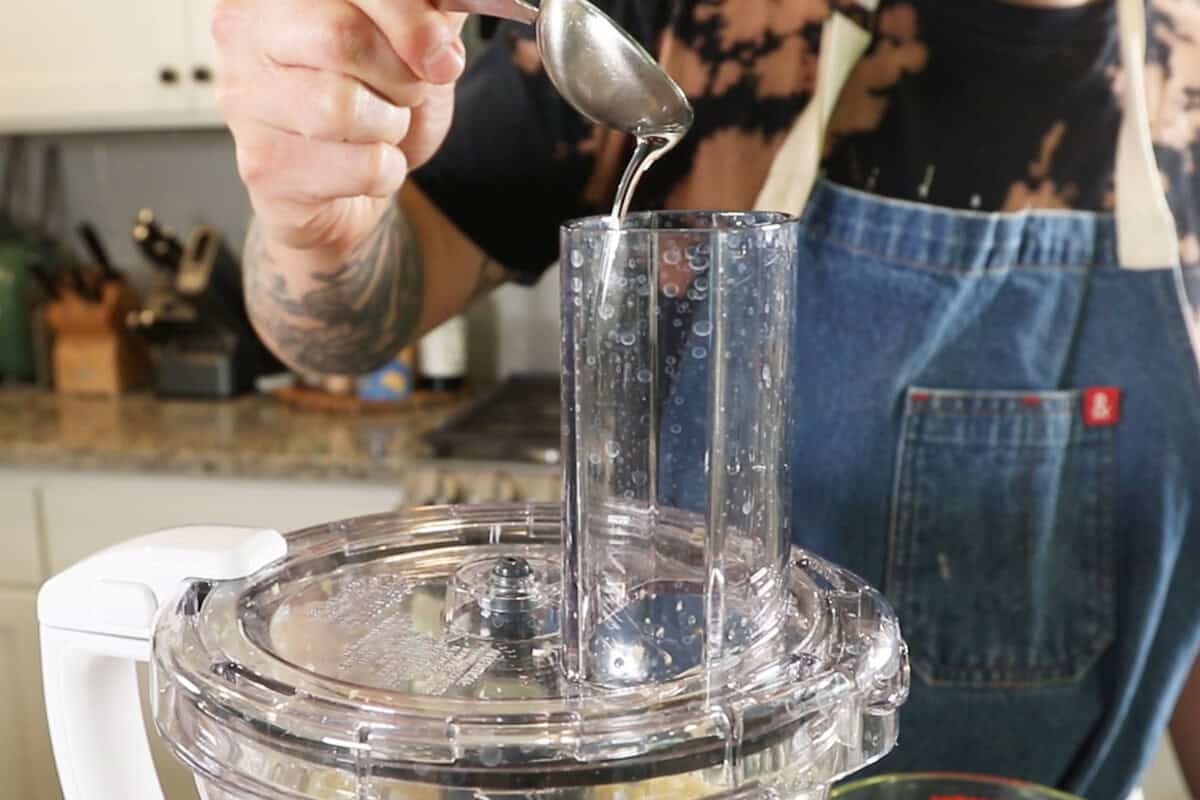 adding oil to a food processor for Lebanese Garlic Sauce (Toum)