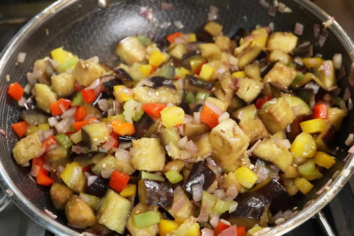 preparing Eggplant Caponata in a large wok