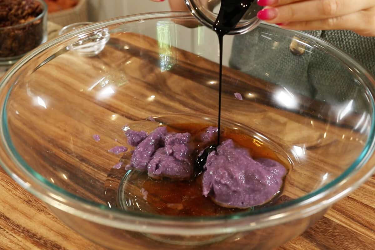 mixing wet ingredients for Ube Coconut Granola in large glass bowl