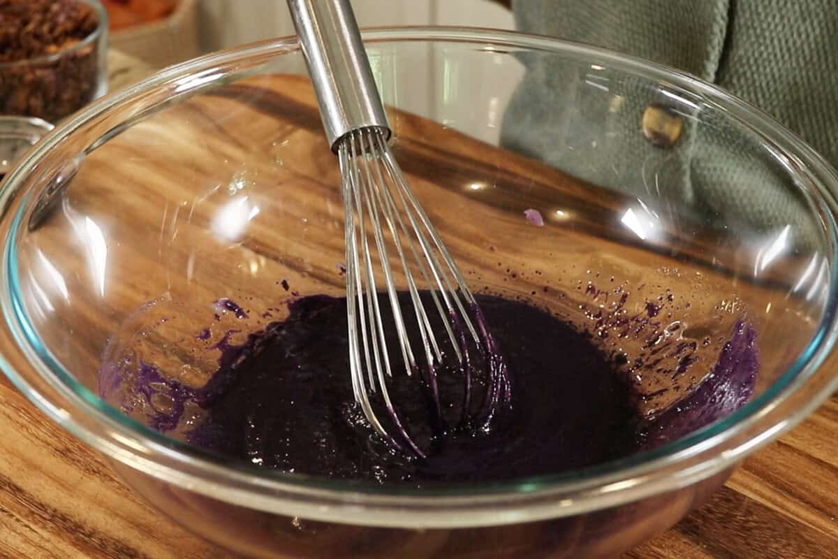 mixing wet ingredients for Ube Coconut Granola in large glass bowl