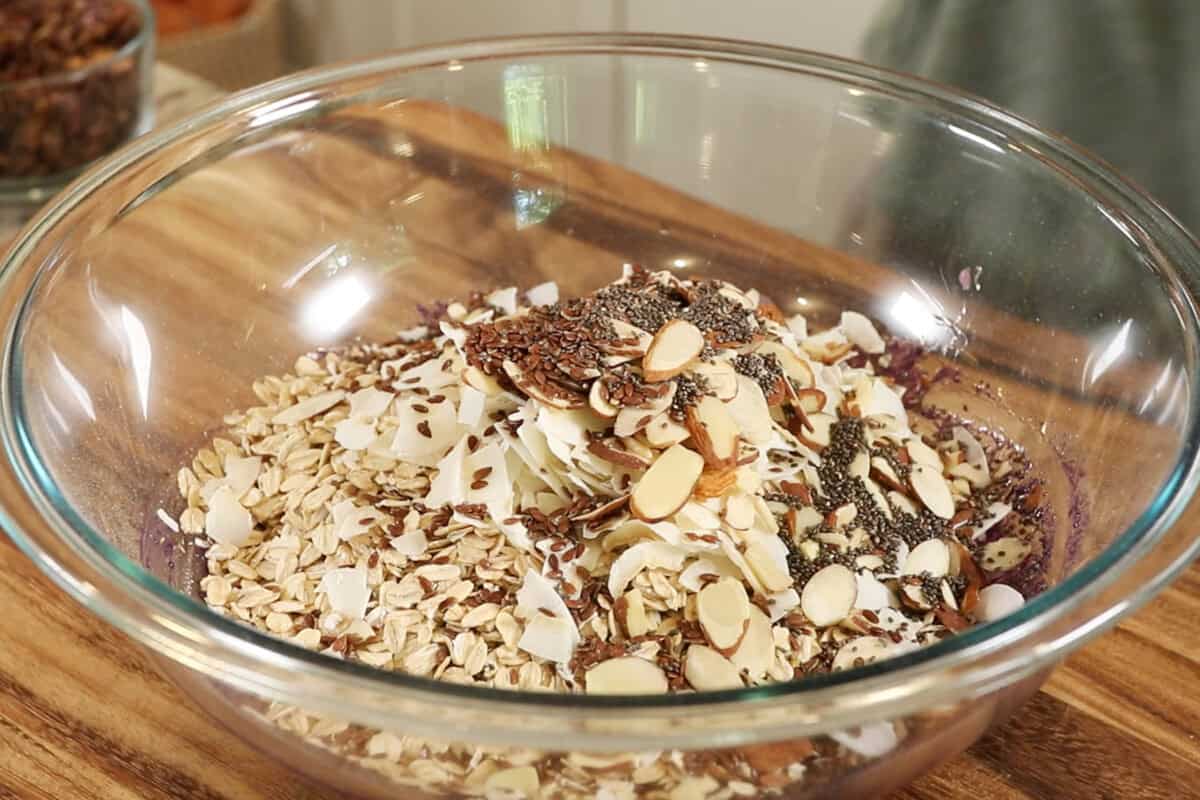 making Ube Coconut Granola in large glass bowl