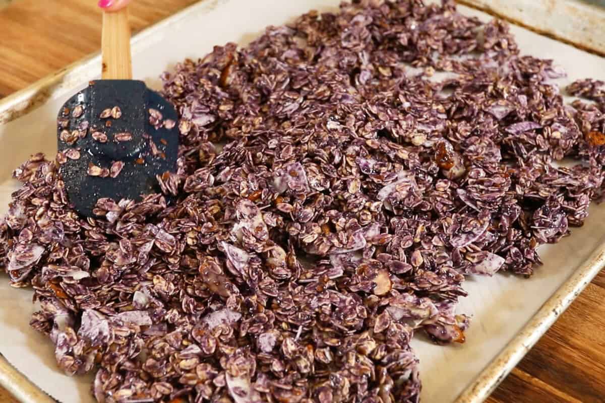 spreading unbaked Ube Coconut Granola on baking sheet