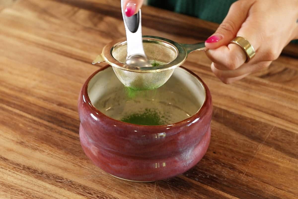 sifting matcha into bowl