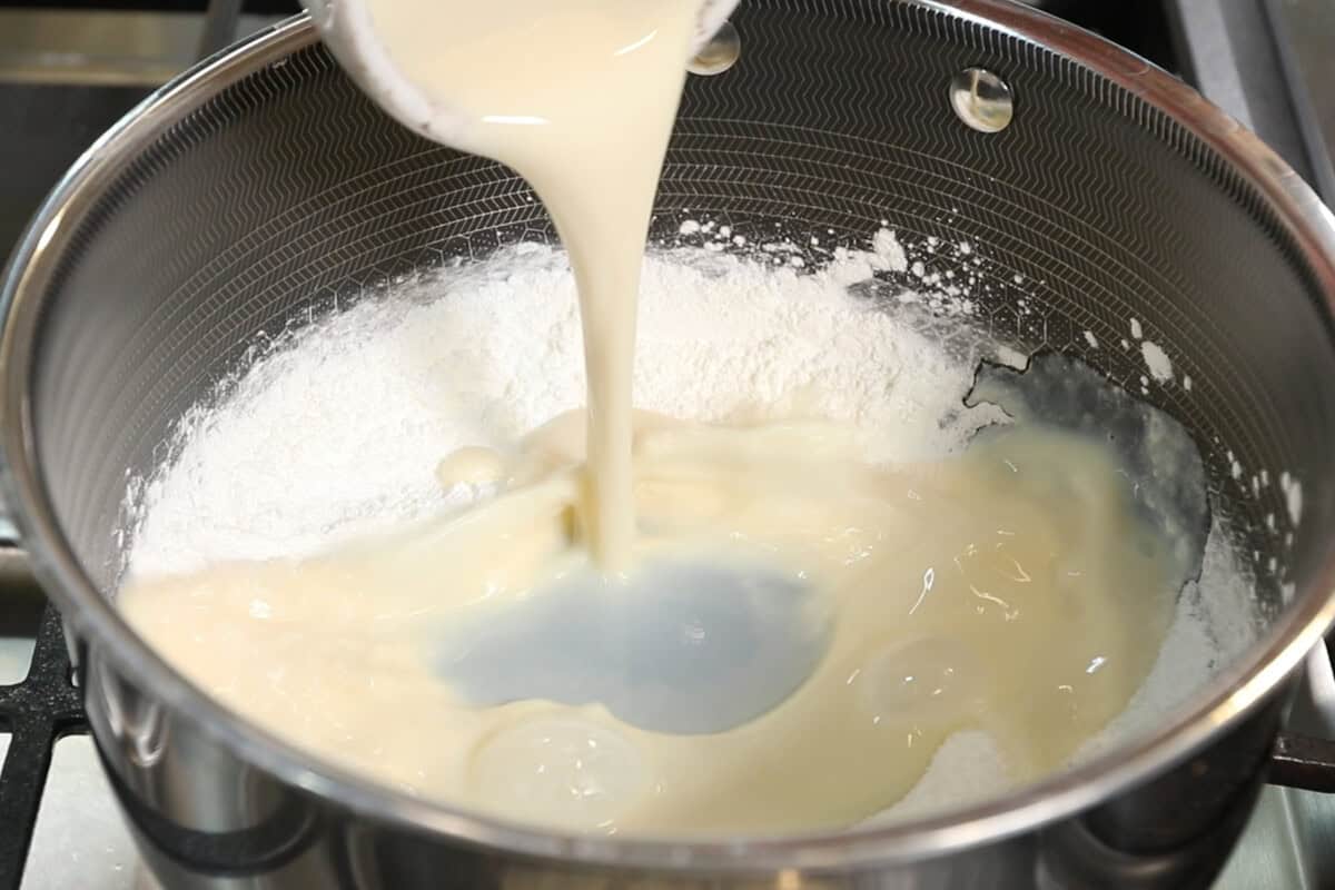 pouring soy milk into pot for custard for Vegan Matcha Crème Brûlée